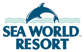 Logo of Sea World Resort featuring a stylized dolphin leaping over blue waves with the text "SEA WORLD RESORT" in green and blue.